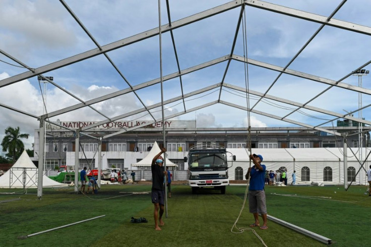 Workers building temporary shelters for coronavirus patients on a football pitch in Yangon, where new infections have spiked prompting opposition parties to call for a postponement of elections due in November