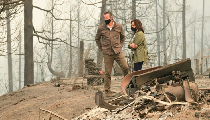 US Democratic vice presidential nominee and Senator from California, Kamala Harris stands with California Governor Gavin Newsom as they assess the damages in a fire-ravaged property from the Creek Fire nearby in an unincorparated area of Fresno, Californi