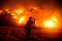 A firefighter works at the scene of the Bobcat Fire burning on hillsides near Monrovia Canyon Park in Monrovia, California on September 15, 2020