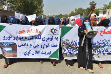 Afghan women hold banners and chant slogans in Jalalabad during a march to show their support for peace talks between Afghan government and the Taliban