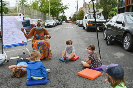 A teacher conducts a lesson with students during an outdoor learning demonstration for New York City schools in front of the Patrick F. Daly public school on September 02, 2020 in the Brooklyn borough of New York City