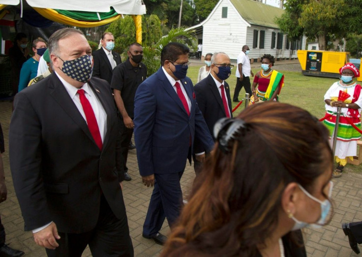 US Secretary of State Mike Pompeo (left) walks past ceremonial drummers following a news conference at Suriname's presidential palace