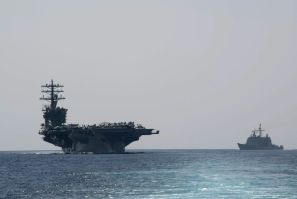 The US Navy aircraft carrier USS Nimitz (L) transits the Strait of Hormuz on September 18