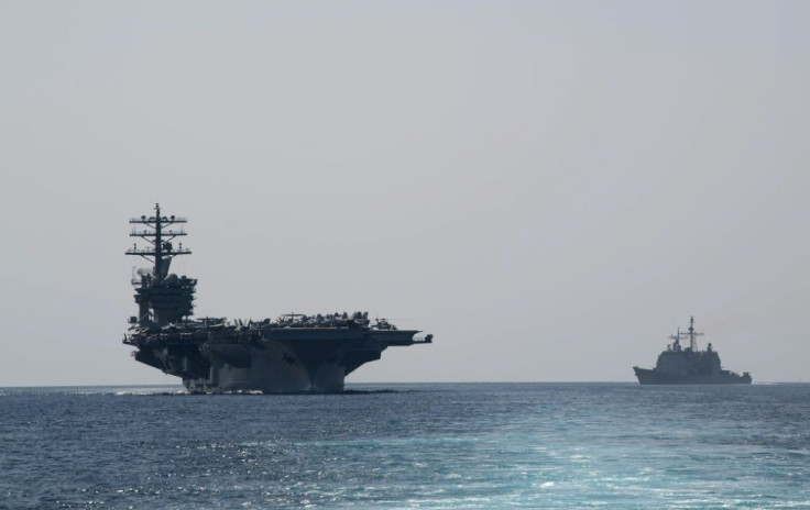 The US Navy aircraft carrier USS Nimitz (L) transits the Strait of Hormuz on September 18