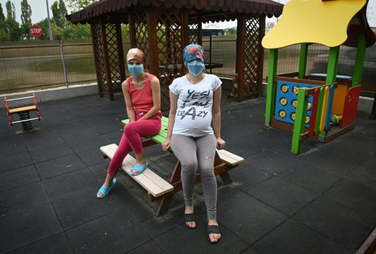Two women are pictured at a centre for victims of domestic violence and trafficking in Romania