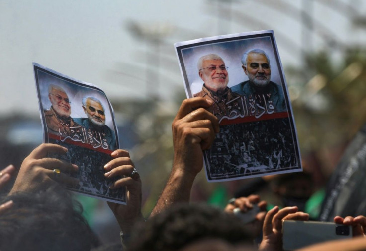 Mourners hold images of Iranian general Qasem Soleimani and senior Iraqi military commander Abu Mahdi al-Muhandis after they were killed in a US drone strike -- both men began their military careers in the Iran-Iraq war