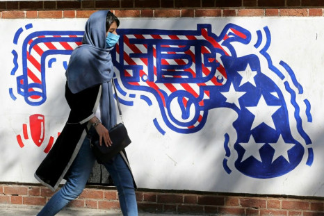 An Iranian woman walks past a mural painted on the outer walls of the former US embassy in Tehran on September 20, 2020