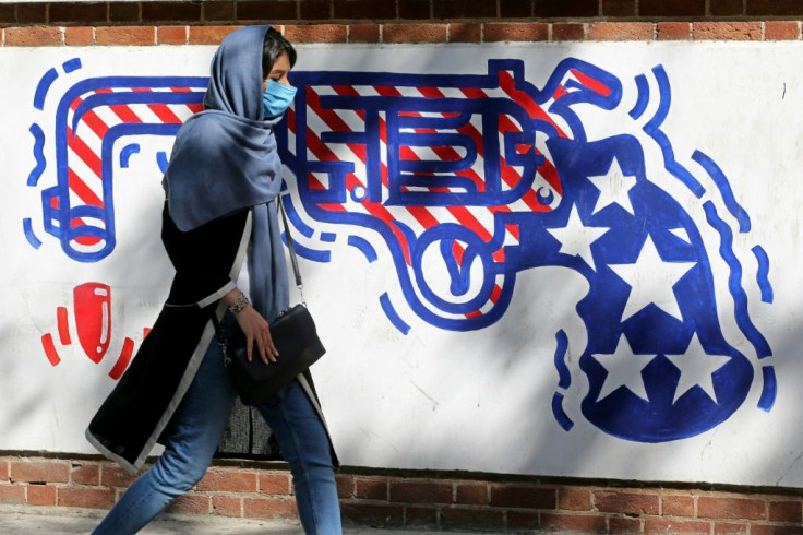 An Iranian woman walks past a mural painted on the outer walls of the former US embassy in Tehran on September 20, 2020