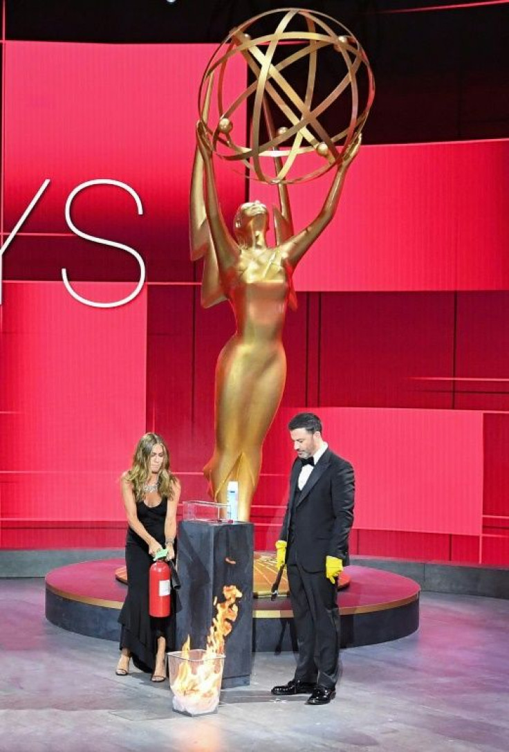 In one early on-stage gag, Emmys host Jimmy Kimmel set an awards envelope on fire to sterilize it, with Jennifer Aniston dousing the flames