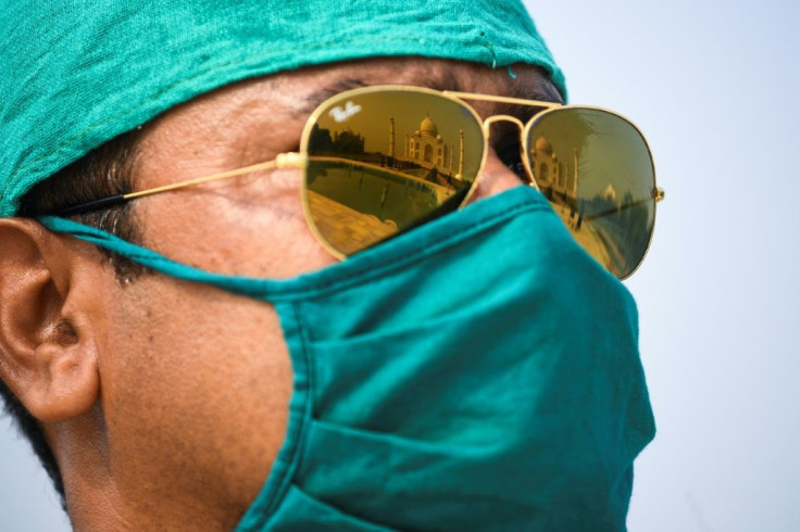 The Taj Mahal in Agra is reflected in the glasses of a guard after it reopened to visitors in a symbolic business-as-usual gesture