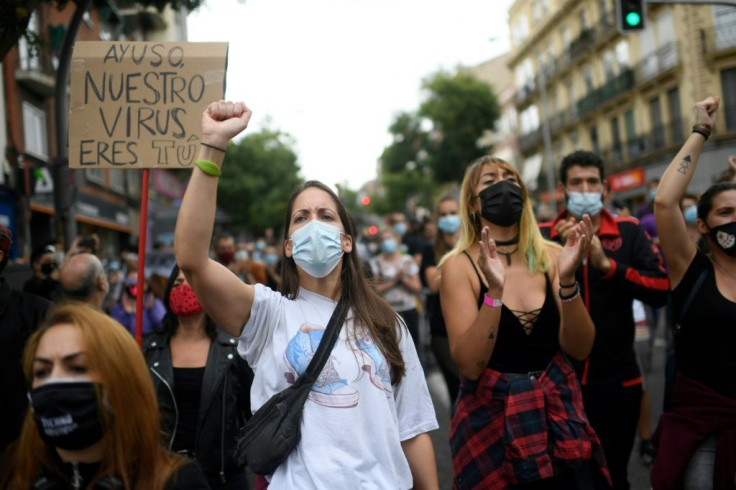 People attend a demonstration at the Vallecas neighborhood in Madrid to protest new restrictive measures announced by regional authorities