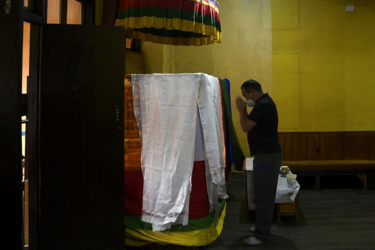 A relative prays in front of the casket of veteran Nepal mountaineer Ang Rita Sherpa in Kathmandu. Ang Rita, nicknamed "snow leopard", climbed the world's highest mountain a record 10 times without bottled oxygen