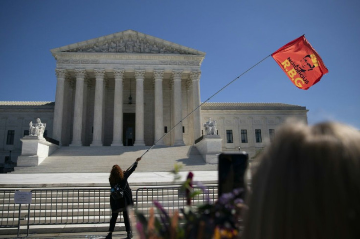 A woman waves a flag honoring Ruth Bader Ginsburg, or 'RBG,' in front of the Supreme Court after the revered judge's death
