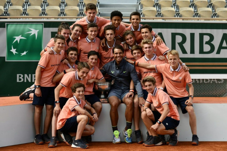 Man of the people: Rafael Nadal poses with ball boys and girls after winning the 2019 French Open