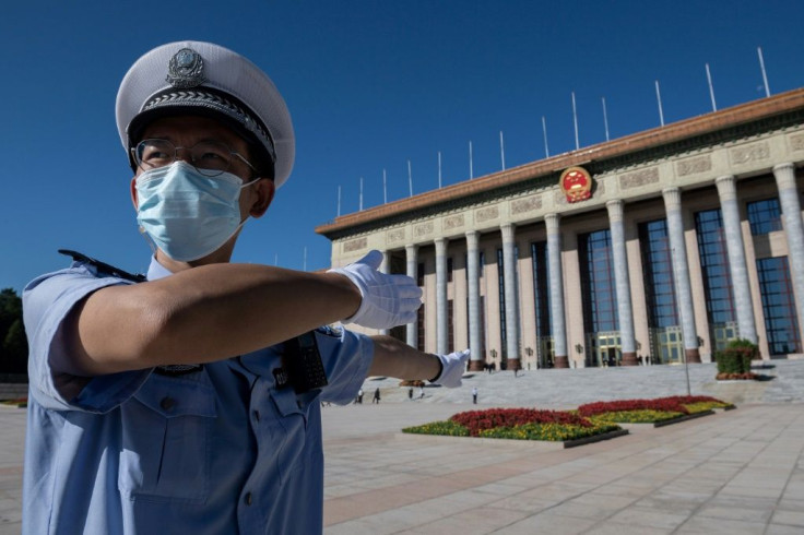 A police officer directs official cars outside the Great Hall of the People ahead of a ceremony to honor people who fought against the Covid-19 coronavirus pandemic in September 2020