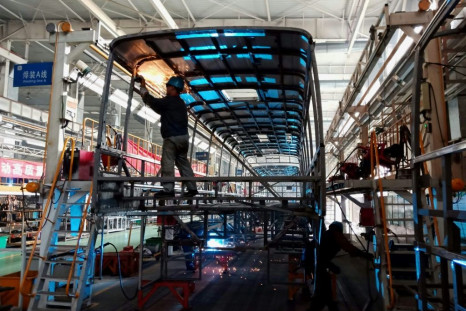 Workers build an electric bus at a factory in Liaocheng in China's eastern Shandong province in December 2018 as the country moves to limit fossil fuel consumption