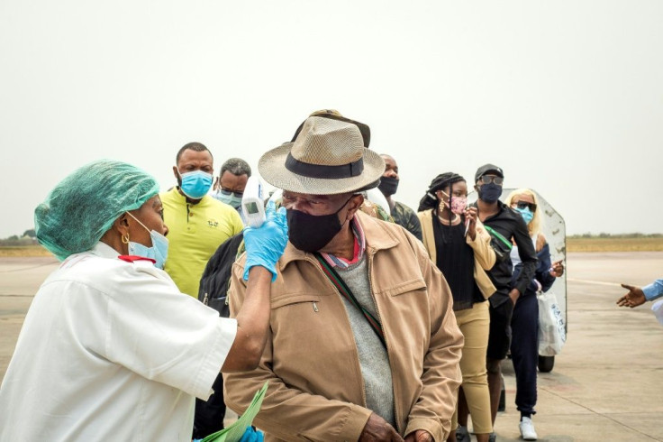 A first responder checks the temperatures of passengers at the Kinshasa airport in August 2020