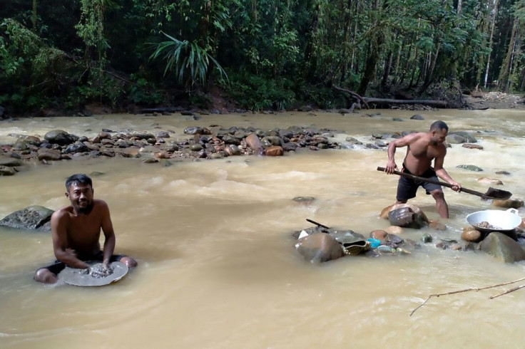 The arduous job of gold panning carries the risk of catching skin infections from wading through waters chock full of waste from the nearby mine