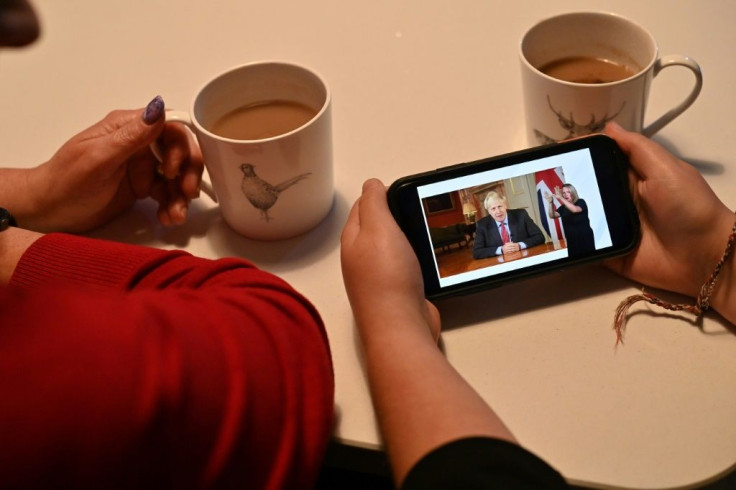 A family watch as Britain's Prime Minister Boris Johnson addresses the nation on Covid-19 restrictions