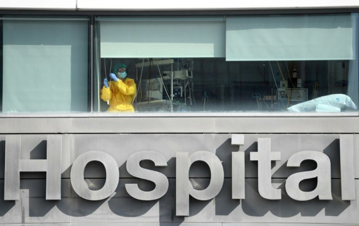 A healthcare worker looks out the window of La Paz hospital, in Madrid, as Spain's health minister calls on residents of the city to limit their movements and social contacts to the "essential"