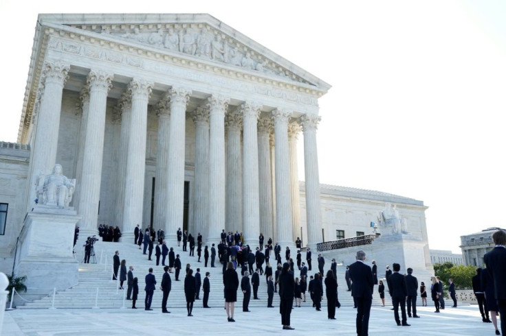 Law clerks and other mourners as Ruth Bader Ginsburg's casket is carried up the steps of the US Supreme Court in Washington, DC, September 23, 2020