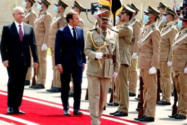 Iraq's President Barham Saleh, who is warning of risks to his country, inspects an honor guard as he welcomes French President Emmanuel Macron (left) on September 2, 2020