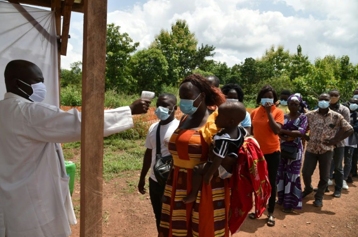 Health ministry workers in Bouake, Ivory Coast check passengers' temperatures to prevent Covid in June 2020