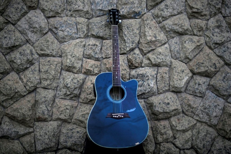 Paulo Roberto's beloved blue guitar, left on a wall after his death from Covid-19