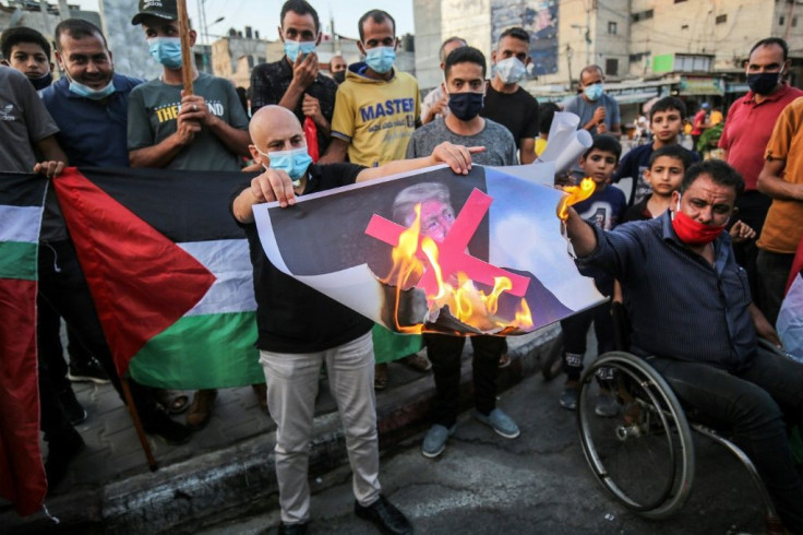 Palestinian demonstrators burn a portrait of US President Donald Trump during a protest in Khan Yunis in the southern Gaza Strip to denounce the Israeli normalization deals with the United Arab Emirates and Bahrain