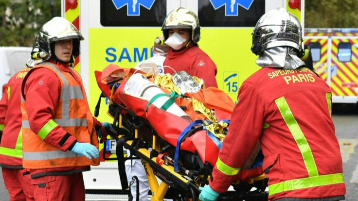 French firefighters evacuate a person injured in a knife attack near the former premises of the satirical weekly Charlie Hebdo in Paris