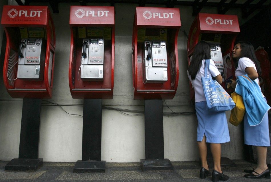 Students use a pay phone on the street in Manila