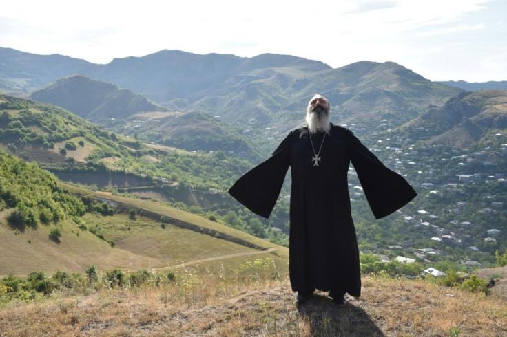 Priest Ter Abel prays for peace outside the village of Movses on the Armenian-Azerbaijani border on July 15, 2020