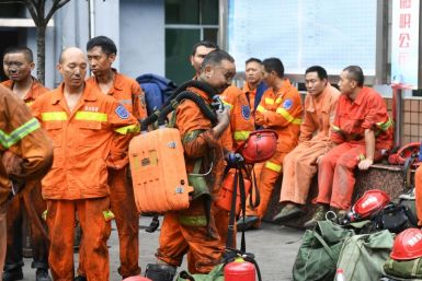 Exhausted rescue workers outside the Songzao mine near Chongqing
