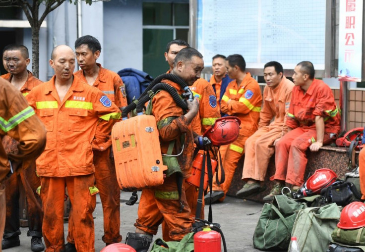 Exhausted rescue workers outside the Songzao mine near Chongqing