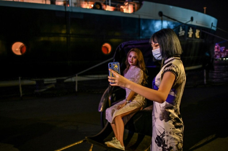 Party-goers in traditional 1920s outfits take pictures before embarking on a theme cruise in Wuhan