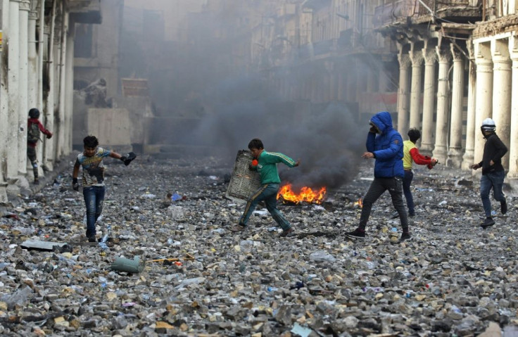 An Iraqi demonstrator holds a makeshift shield amid clashes with security forces in the capital Baghdad's Al-Rasheed street near Al-Ahrar bridge in November 2019