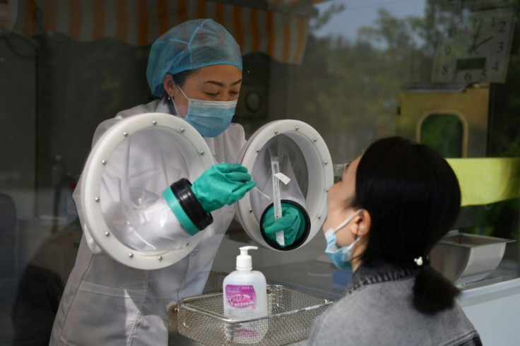 A technician takes a sample from a staff member at Chinese biotech company Coyote