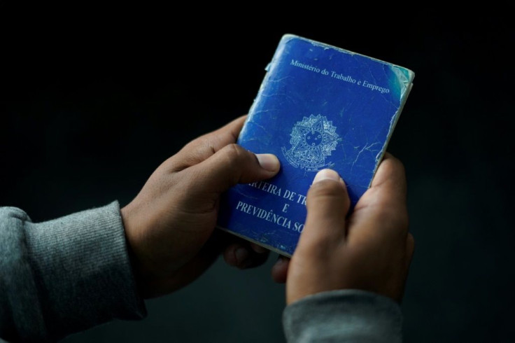 A man holds his work document during a job fair in Rio de Janeiro, Brazil -- unemployment in the country has risen to a record 13.8 percent