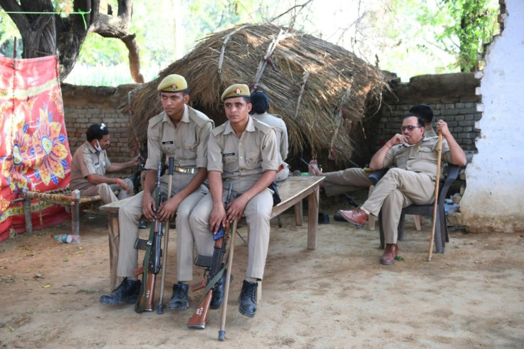 Uttar Pradesh Police personnel keep watch outside the family house of a low-caste teenager who died after allegedly being gang-raped by four men from a wealthy landowning family
