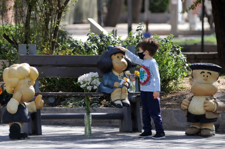 A child touches a statue depicting Mafalda, the comic strip character created by Argentinian cartoonist Joaquin Salvador Lavado, known as Quino, who died on Wednesday