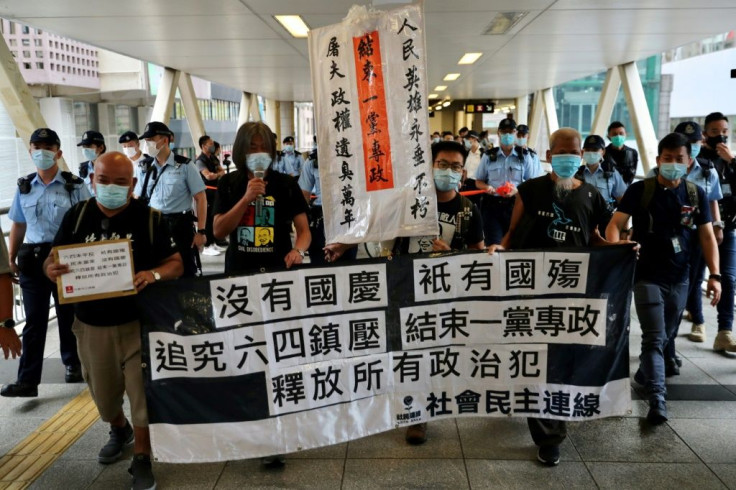 Activists from the League of Social Democrats, including Leung Kwok-hung, also known as 'Long Hair' (2nd L), take part in a demonstration as police follow closely during China's National Day in Hong Kong