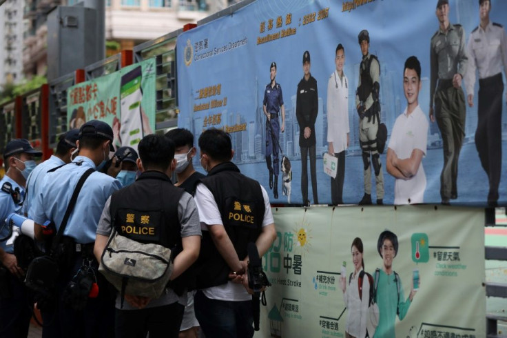 Police stop pedestrians as they patrol to deter protests during China's National Day in Hong Kong