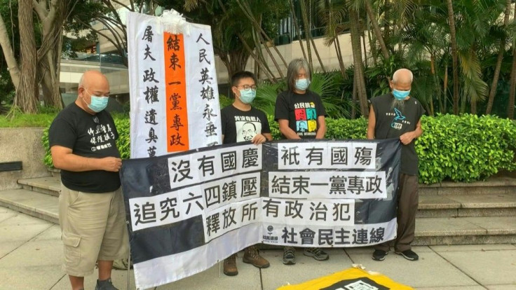 Four Hong Kong pro-democracy activists march towards the venue of an official ceremony to celebrate China's National Day, chanting slogans such as "End one party rule" while surrounded by some 40 police officers.