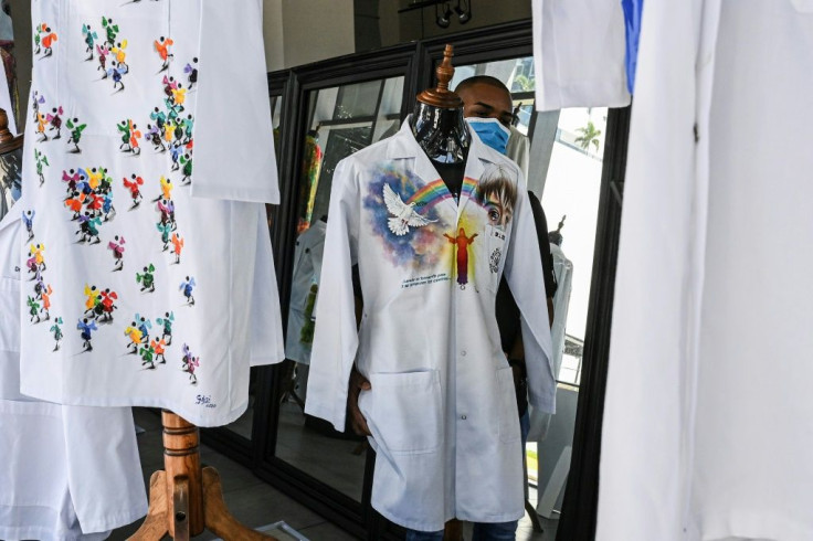 A gallery worker organizes a display featuring the doctors' coats in Panama City