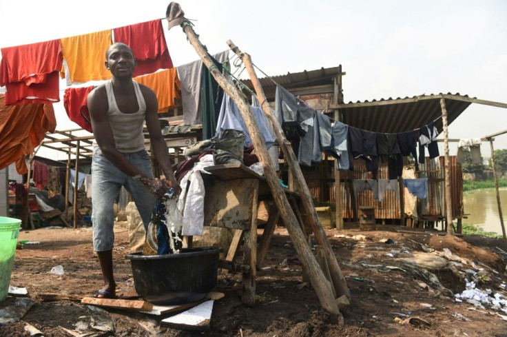 A man washes clothes outside his home in Isheri Kara in Ogun state. Poverty, as well as corruption that has siphoned off vast oil wealth, is entrenched in Nigeria
