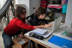 Cinthia Pergola helps her son Francisco during an online class at their home in Sao Paulo, Brazil amid the novel coronavirus pandemic