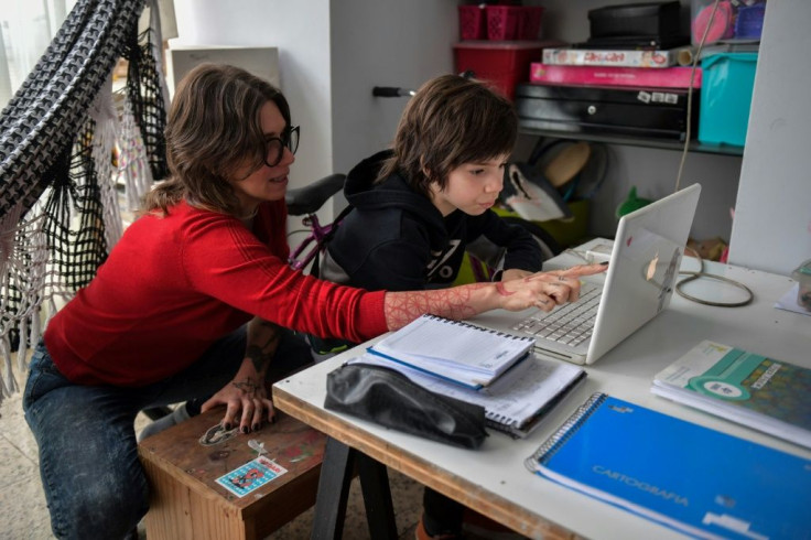 Cinthia Pergola helps her son Francisco during an online class at their home in Sao Paulo, Brazil amid the novel coronavirus pandemic