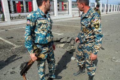 Servicemen of Karabakh's Emergencies Ministry stand outside the ministry's building which it said was damaged by Azeri shelling