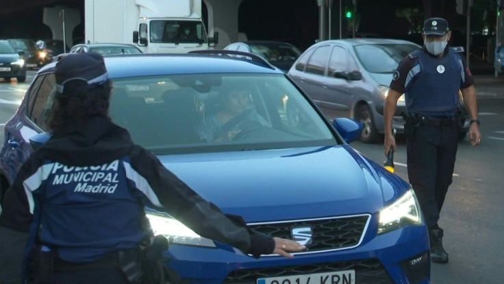 Police officers control cars in a neighbourhood of the Spanish capital