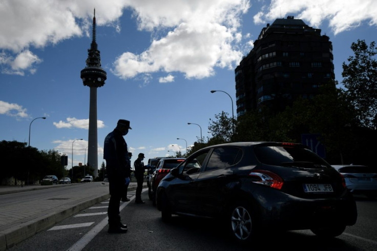 Masked police set up temporary checkpoints in Madrid after a partial lockdown was imposed